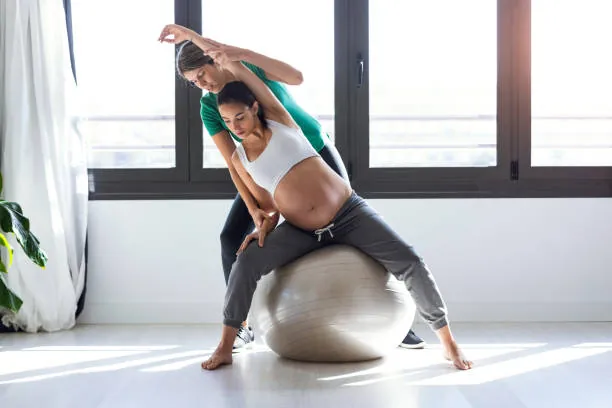 Esercizio su fitball durante il Pilates in gravidanza, con l'istruttrice